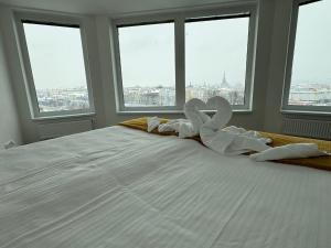a large white bed with two swans made out of towels at Sky Apartments 506 in Plzeň