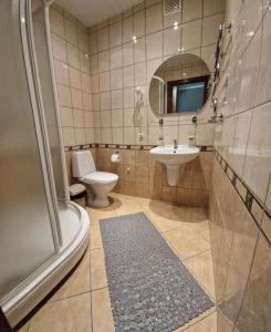 e bagno con servizi igienici, lavandino e doccia. di Hotel Linda - Helvita a Liepāja