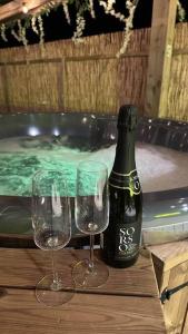 - deux verres et une bouteille de vin assis sur une table dans l'établissement Clyde Croft - (Luxury Cabin), à Portpatrick