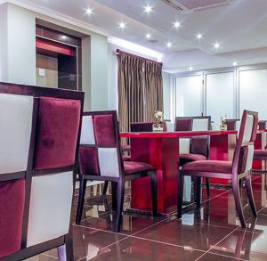 a dining room with a red table and chairs at Tamboti Guest Lodge in Pretoria