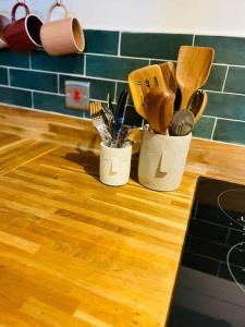 2 tazas llenas de utensilios en la encimera de la cocina en Clyde Croft - (Luxury Cabin) en Portpatrick