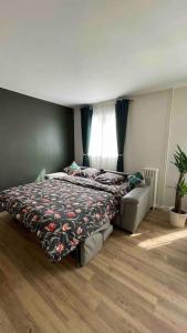 - une chambre avec un lit et un canapé dans l'établissement Bel appartement proche de Paris, à Villemomble