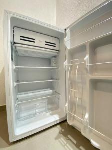 an empty refrigerator with its door open in a kitchen at Noronheiro Boutique & House in Fernando de Noronha