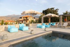 a patio with blue pillows and a swimming pool at Lampetos Houses Molyvos in Mythimna