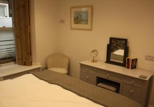 a bedroom with a bed and a desk and a mirror at Vintage Beach House in Lower Largo
