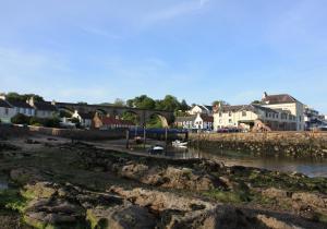 a river with houses and a bridge in the background at Vintage Beach House in Lower Largo