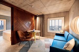 a living room with a blue couch and a table at Villa Viva - ein Haus das Brunnen baut in Hamburg