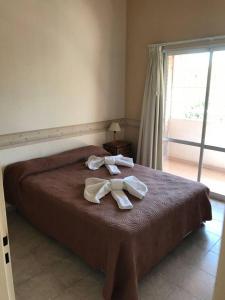 1 dormitorio con 1 cama con 2 toallas en Amueblados Neuquen ALTO COMAHUE SHOPPING III en Neuquén