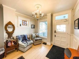 a living room with two chairs and a chandelier at New 1BR Apartment in Heart of Downtown Pueblo! in Pueblo