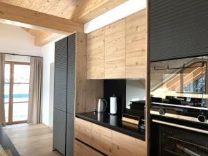 a kitchen with a black counter and wooden cabinets at Alpen Luxury Lodge, MARIAZELL - Adults only in Mariazell +90 photos