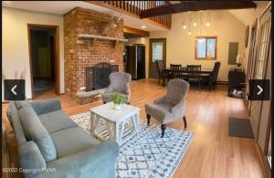a living room with a couch and chairs and a fireplace at Rosie’s Cabin in Thornhurst