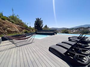 une terrasse avec des chaises longues et une piscine dans l'établissement Confortable y Centrico Depto Papudo, à Papudo