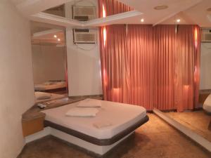um quarto com uma cama, uma cortina e um espelho em Jumbo Hotel (Adults Only) no Rio de Janeiro