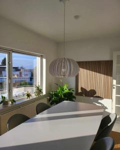 a dining room with a table and chairs and a large window at Moderne villalejlighed på 110 kvm + stor terrasse in Viby