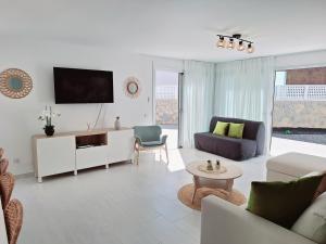 Una sala de estar con un sofá y un televisor. en Malibú Mogán Secret Pool Villa - Piscina privada y climatizada - Exclusive Heated Pool, en La Playa de Tauro