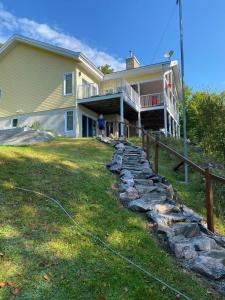 a house with a stone path in front of it at Club Loisirs Nautiques Quebec in Lac-aux-Sables