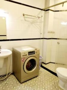 a washing machine in a bathroom with a toilet at Flat near SGN Ho Chi Minh City Airport in Ho Chi Minh City