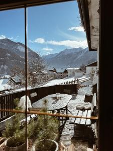 a view of a balcony with a table and snow covered mountains at Ferienhaus Alpenglück in Wenns