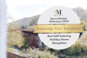 um sinal para o melhor da jardineira britânica com uma ponte em Ironbridge View Townhouse - Stunning view of the Iron Bridge UK WINNER 2024 'MOST PICTURESQUE SELF-CATERING HOLIDAY HOME' of the year' & WINNER '2024 BEST HOLIDAY HOME IN SHROPSHIRE' em Ironbridge