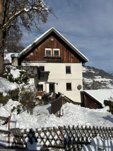 a house with snow on the ground in front of it at Ferienhaus Alpenglück in Wenns
