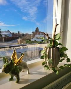 een kattenbeeldje en een plant op een vensterbank bij Moderne villalejlighed på 110 kvm + stor terrasse in Viby