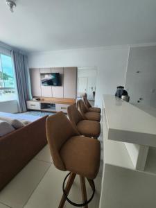 a living room with a row of chairs and a counter at Apartamento Balneário Camboriú in Balneário Camboriú