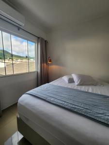 巴拉奈里奧－坎布里烏的住宿－Apartamento Balneário Camboriú，一间卧室配有一张床,享有海滩美景