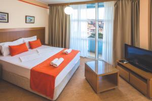 a hotel room with a bed and a television at Apartments Deus in Dobra Voda