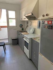 a kitchen with a white refrigerator and a sink at APARTAMENTO PLAYA URB PRIVADA 2 Habitaciones in Valencia