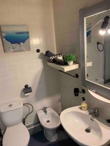a bathroom with a white toilet and a sink at APARTAMENTO PLAYA URB PRIVADA 2 Habitaciones in Valencia