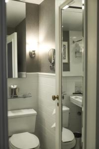 a bathroom with a toilet and a sink and a mirror at Delta Hotels by Marriott Bessborough in Saskatoon