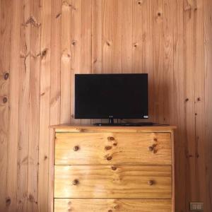 een televisie bovenop een houten dressoir bij Comoda Cabaña en Pichilemu in Pichilemu