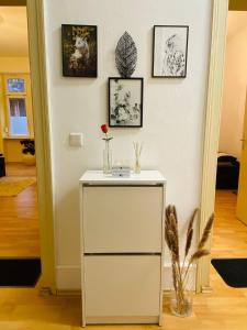 um armário branco com um vaso sobre ele em uma sala em Modernisierte, traumhafte Wohnung in zentraler Lage em Wiesbaden