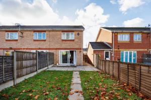 a brick house with a fence and a yard at Charming 2bed House in Barking