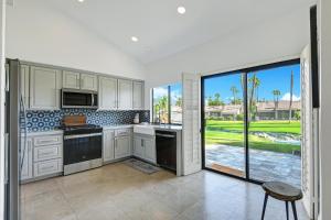 une cuisine avec des placards blancs et une grande fenêtre dans l'établissement VB940 - Lobelia Luxe, à Palm Desert