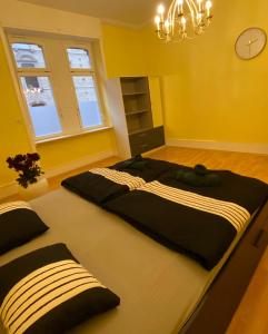 2 łóżka w pokoju z żółtymi ścianami w obiekcie Modernisierte, traumhafte Wohnung in zentraler Lage w mieście Wiesbaden