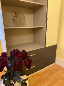 wazon wypełniony czerwonymi różami w szafie w obiekcie Modernisierte, traumhafte Wohnung in zentraler Lage w mieście Wiesbaden