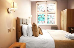 a bedroom with a bed with pillows and a window at Old Market Apartments in Altrincham
