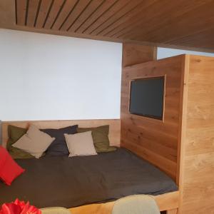 a room with a bed with a flat screen tv at Exklusiv Apartment Sonnenalp in Niederau