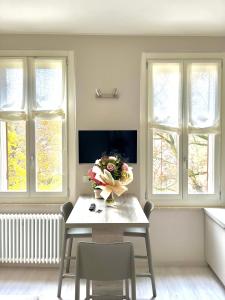 a dining room with a table with a vase of flowers at Maison del Ducato Suite Correggio in Parma