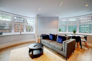 a living room with a couch and a table and windows at Old Market Apartments in Altrincham