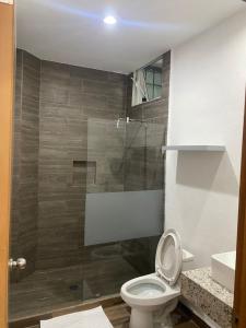 a bathroom with a toilet and a glass shower at Lofts Terra Nuevo Vallarta in Nuevo Vallarta