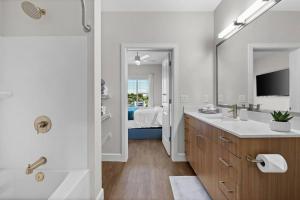 een badkamer met een bad en een wastafel en een tv bij Beverly Hills Suite Penthouse The Gulch in Nashville +24 foto's