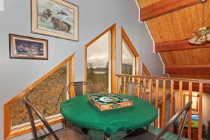 a dining room with a green table and stairs at 140 - Kaisers Cozy Cabin in Big Bear Lake