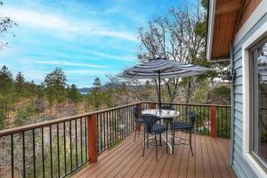 a balcony with a table and chairs and an umbrella at 140 - Kaisers Cozy Cabin in Big Bear Lake