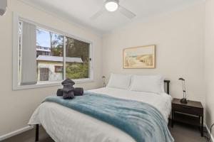 a bedroom with a bed with a teddy bear sitting on it at Rocks Place by Experience Jervis Bay in Vincentia