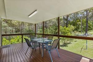 a dining room with a table and chairs on a deck at Rocks Place by Experience Jervis Bay in Vincentia +10 photos