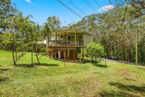a house in the middle of a yard with trees at Rocks Place by Experience Jervis Bay in Vincentia