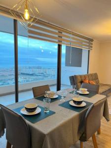 a dining room table with a view of the ocean at Elegante apto, auto check-in, parking gratis. in Antofagasta