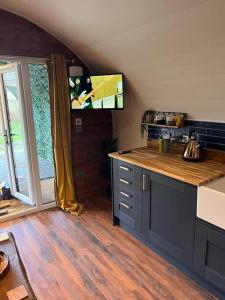 a kitchen with a tv in the corner of a room at Portside Pasture - (Luxury Cabin) in Portpatrick